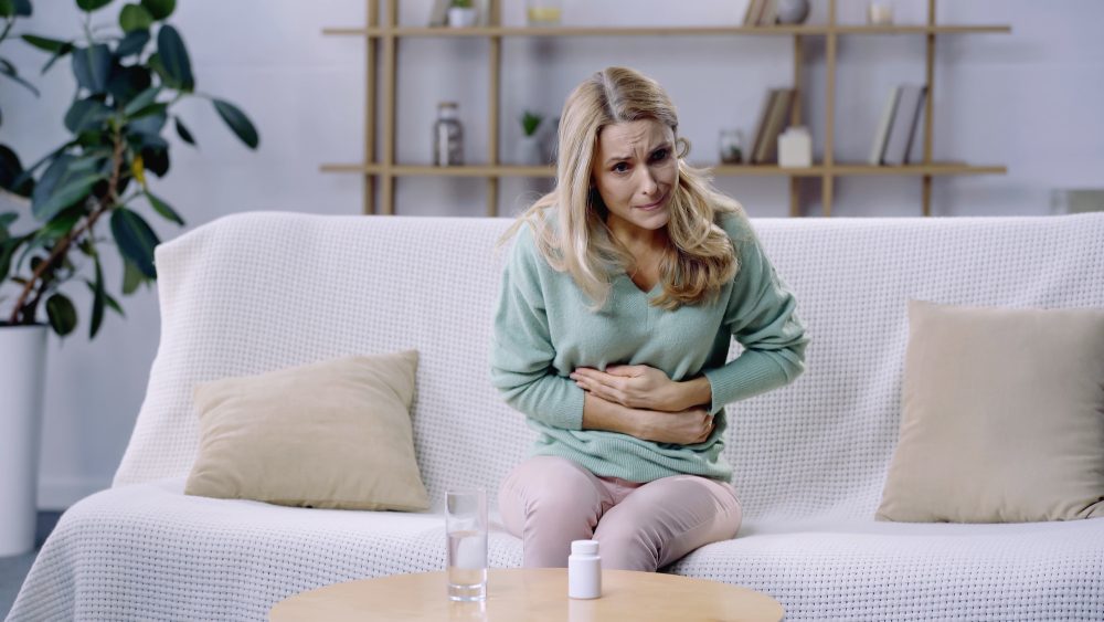 Mulher com estômago embrulhado e dor de cabeça